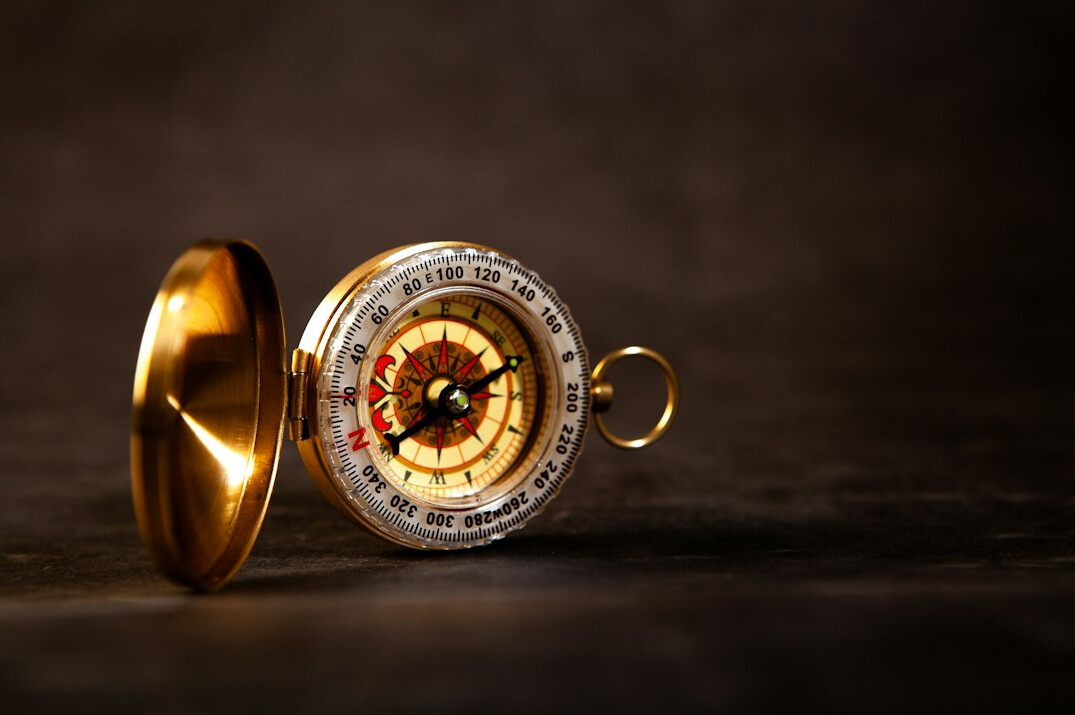 Brass compass lying on a planning map and notes