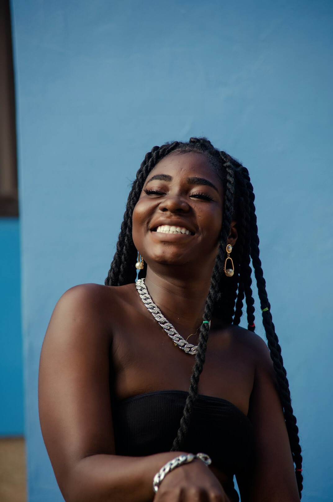 Smiling woman with braided hair in a black top