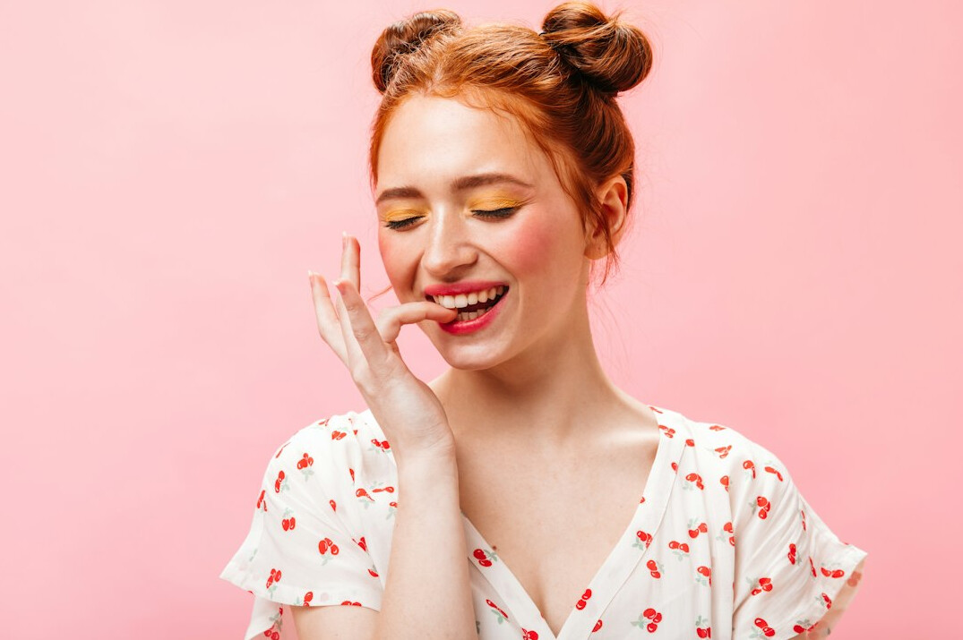 Cheerful woman with wavy dark hair and red top laughing